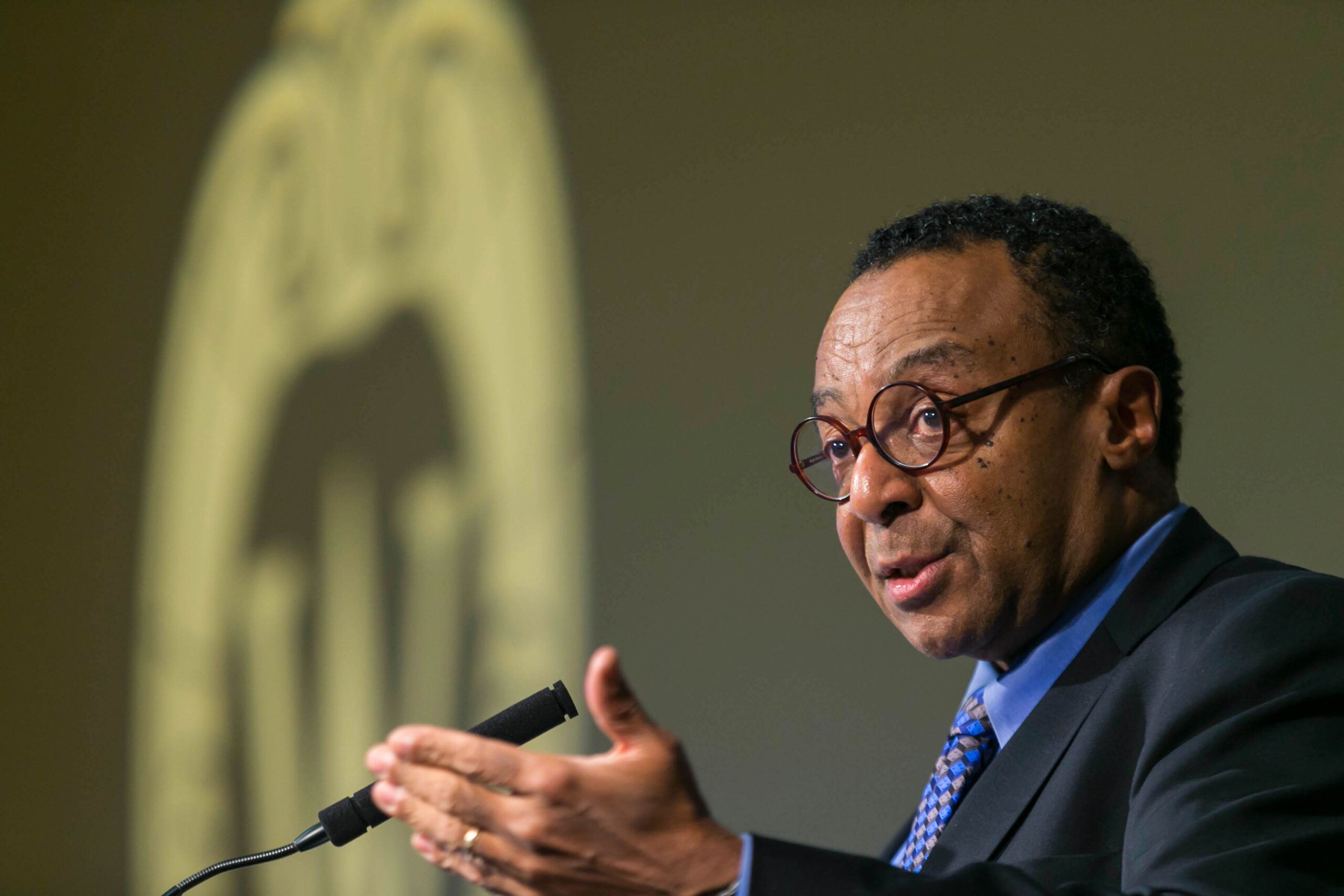 Clarence Page gestures and speaks into a microphone.